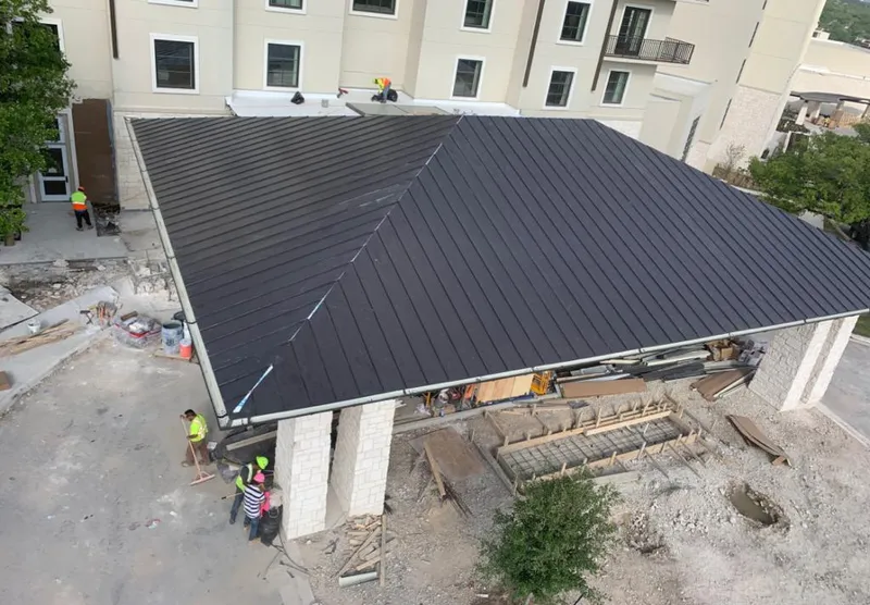 Metal roofing installation team working on a commercial building in Huron
